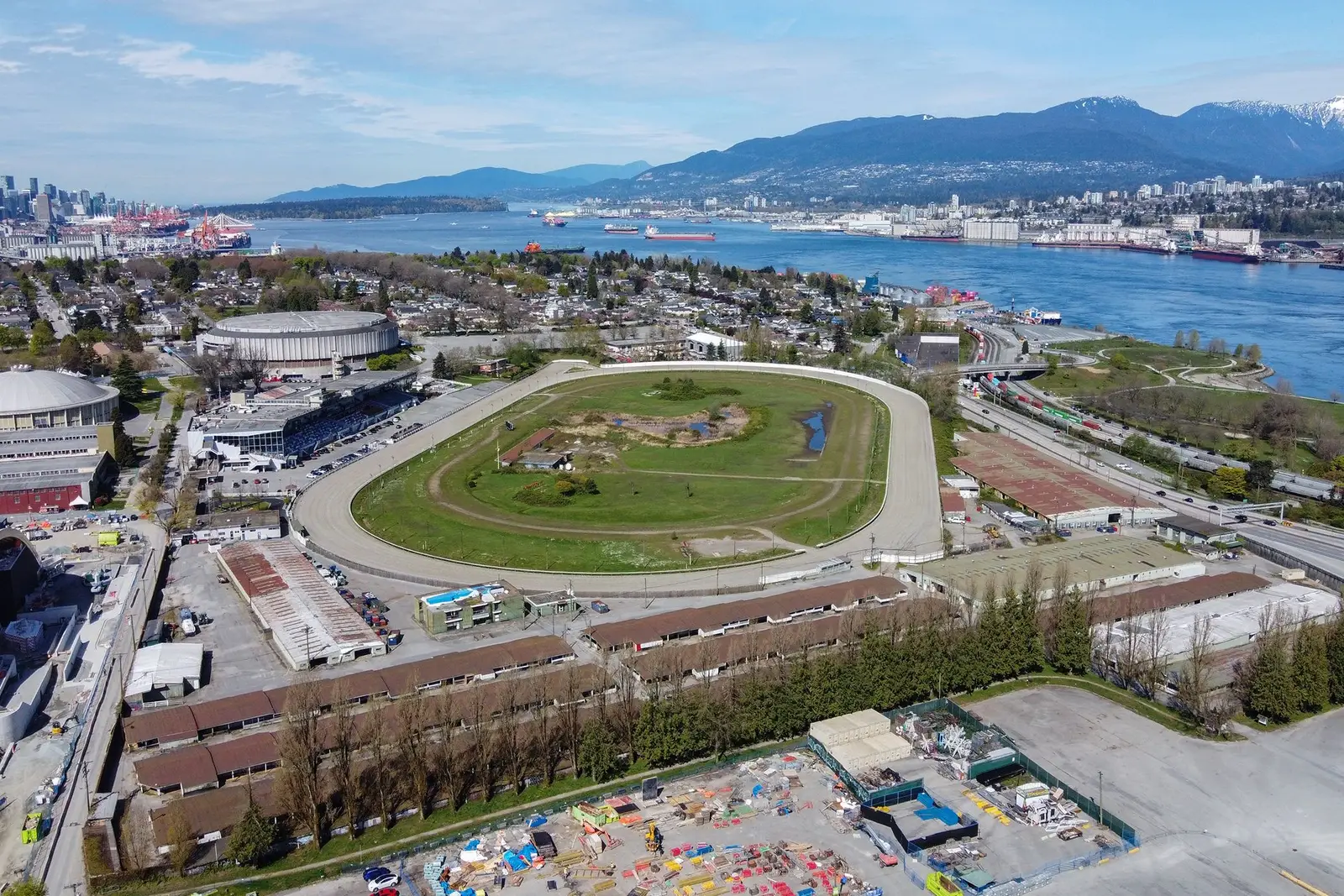 Aerial view of Hastings Racecourse and its grandstand in Hastings Park, with Burrard Inlet and the North Shore mountains behind